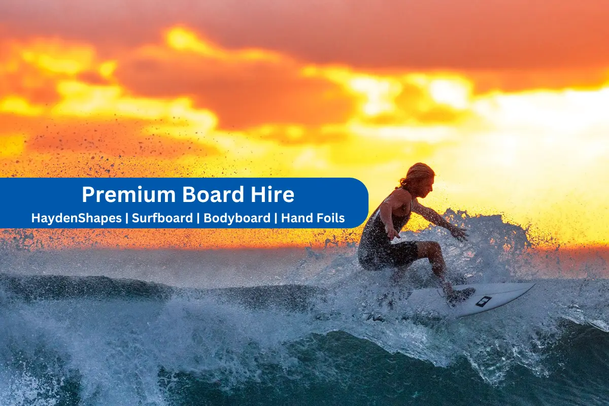 Surfer riding wave on rental surfboard at Noosa main beach